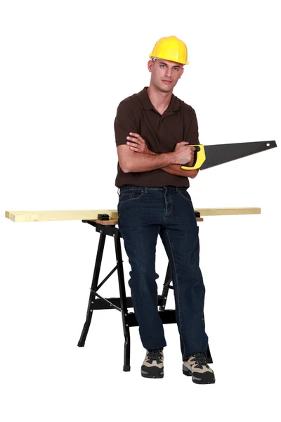 Carpinteiro com uma serra manual — Fotografia de Stock