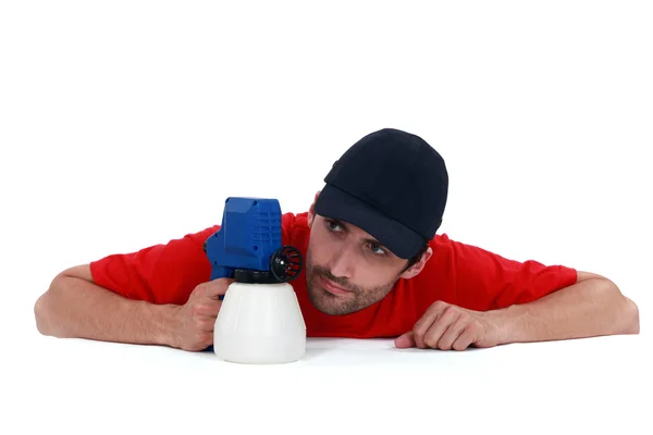 Un pintor examinando su pistola. . — Foto de Stock