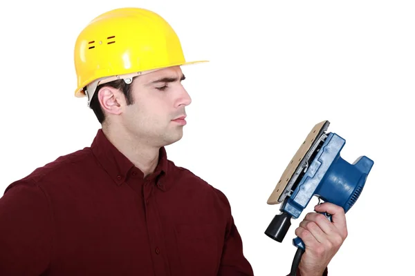 Woodworker looking at a sander — Stock Photo, Image