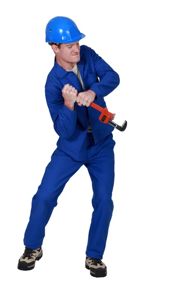 Tradesman trying to force open an object using a pipe wrench — Stock Photo, Image