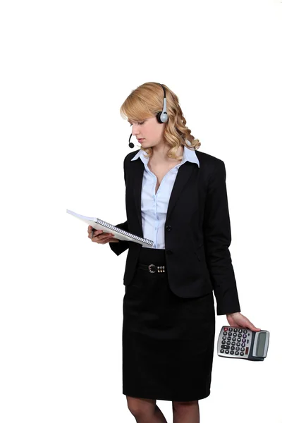 Mujer con calculadora y cuaderno en la mano — Foto de Stock