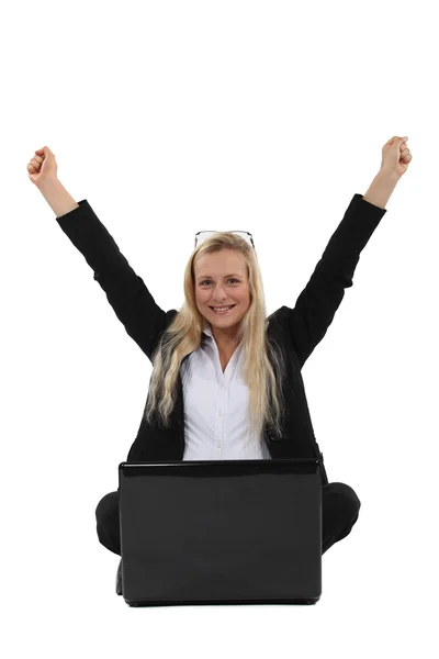 A victorious businesswoman sitting on the floor. Stock Image