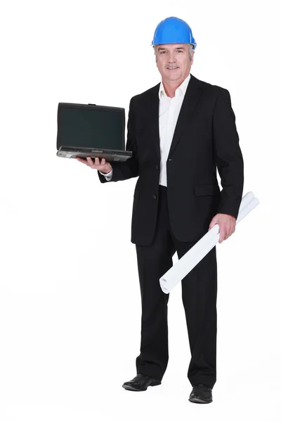 Senior businessman wearing a helmet and holding a blueprint and a laptop — Stock Photo, Image