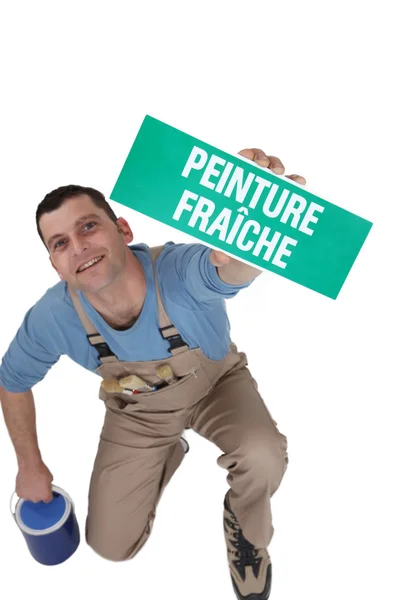 Homme à tout faire montrant signe pour la peinture fraîche — Photo