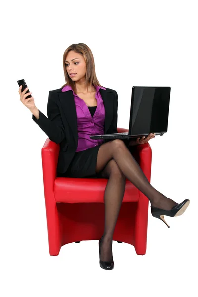 Femme assise avec téléphone portable et ordinateur — Photo