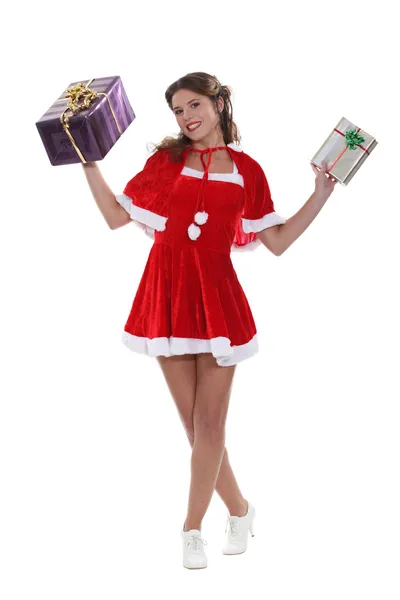 Sonriente señorita Santa sosteniendo en alto algunos regalos de Navidad — Foto de Stock