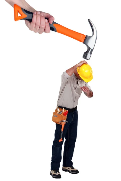 Builder being attacked by giant hammer — Stock Photo, Image