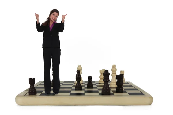Businesswoman standing on chess board — Stock Photo, Image