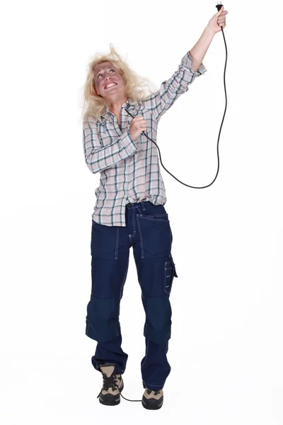 Chocado eletricista feminino segurando cabo — Fotografia de Stock