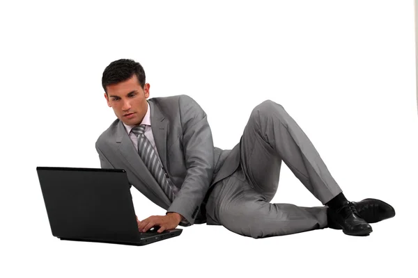 Zakenman die op de vloer met laptop — Stockfoto