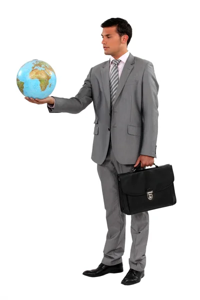 Businessman with briefcase holding globe — Stock Photo, Image