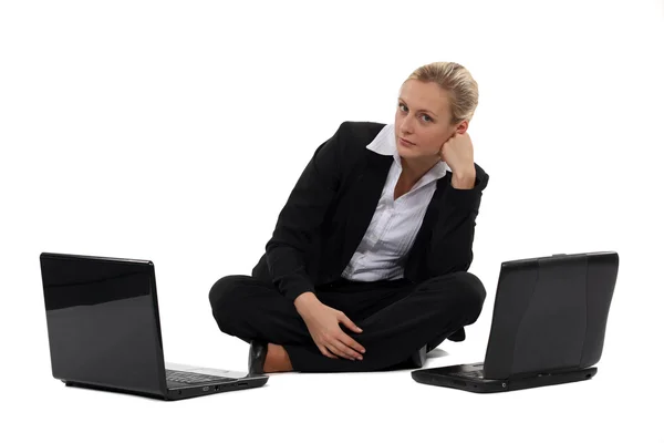 Woman sat with two laptops — Stock Photo, Image