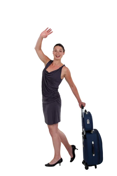 Jovem com bagagem acenando adeus — Fotografia de Stock