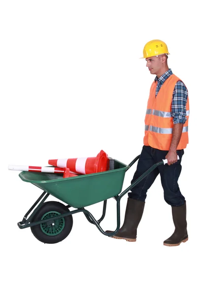 Camisola de tijolo com carrinho de mão e cone de construção — Fotografia de Stock