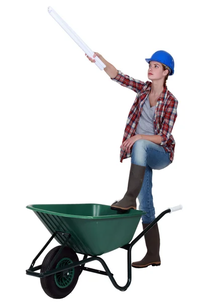 Female worker with plans and a wheelbarrow — Stock Photo, Image