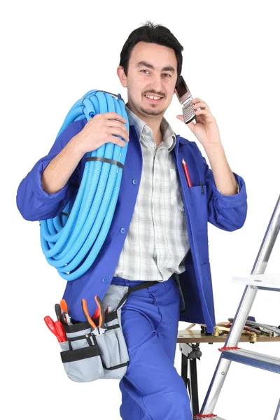 Plumber with materials, toolbox and cellphone — Stock Photo, Image