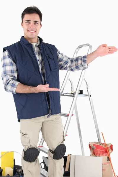 Man gesturing towards tile cutting equipment — Stock Photo, Image