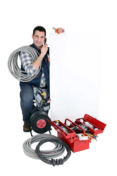 Tradesman posant avec un signe vierge et ses outils — Photo