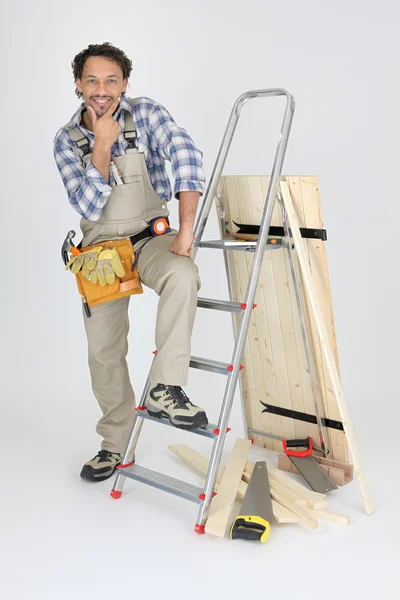 Portret van schrijnwerker poseren in de buurt van ladder — Stockfoto