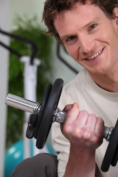 Молодий чоловік використовує ваги в спортзалі — стокове фото