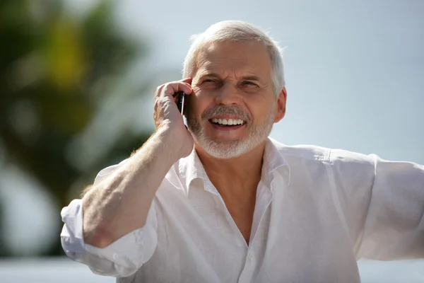 Homem mais velho feliz com um celular — Fotografia de Stock