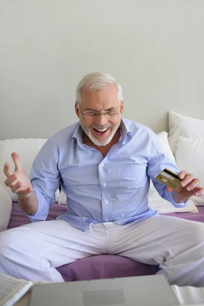 Směje se starší koupí něco online — Stock fotografie