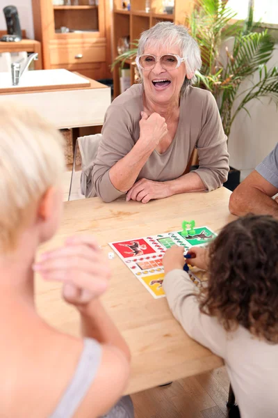 Família jogando um jogo de tabuleiro — Fotografia de Stock