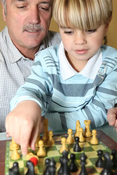 Homem sênior e neto jogando xadrez — Fotografia de Stock