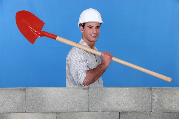 Bricklayer carrying a spade — Stock Photo, Image