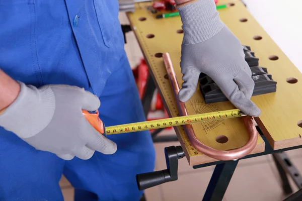 Plumber measuring coper pipe — Stock Photo, Image