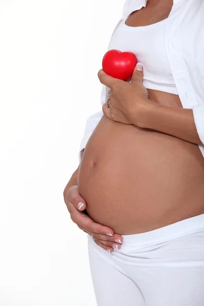 Mujer embarazada sosteniendo una manzana roja — Foto de Stock
