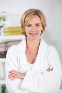 35-40 years old blonde woman dressed in bathrobe in her bathroom clipart