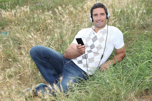 Man luisteren naar muziek in het park — Stockfoto