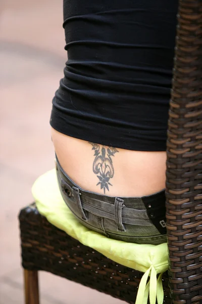Woman with a tattoo on her lower back — Stock Photo, Image