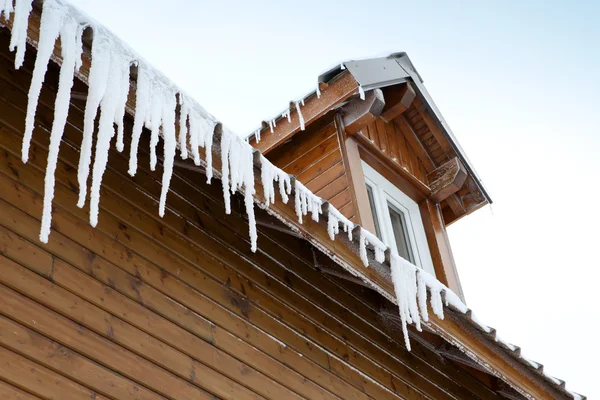 Icicles hanging from a roof edge — Stock Photo, Image