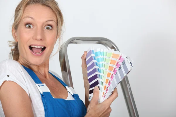 女人站在梯子持有油漆色板 — 图库照片
