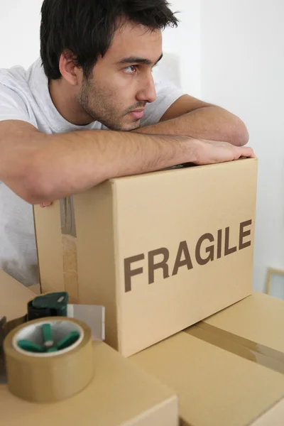 Hombre apoyado en una pila de cajas — Foto de Stock