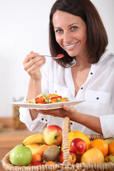 Mujer comiendo ensalada de frutas —  Fotos de Stock