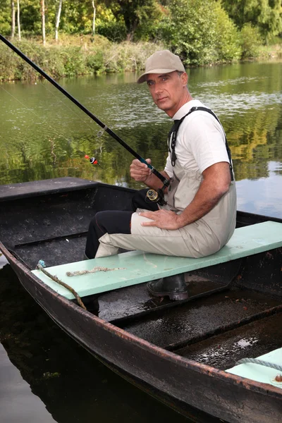 Rybář sedět v lodi — Stock fotografie