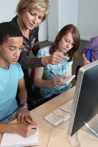 Teacher helping pupils with their assignment — Stock Photo, Image