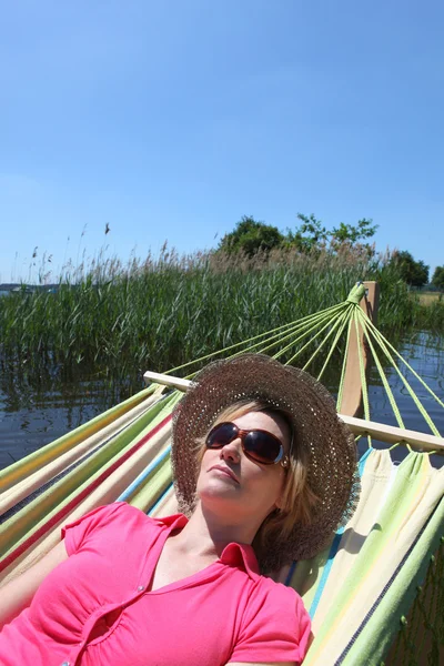 Woman in hammock by lake — Stock Photo, Image