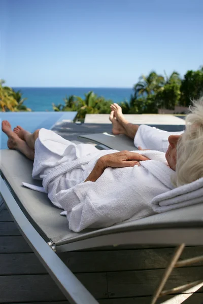 Senior couple relaxing poolside — Stock Photo, Image