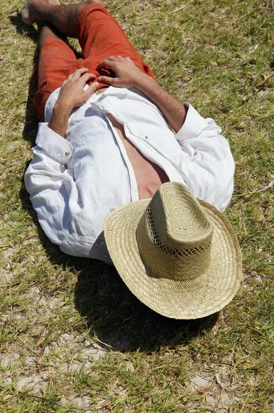 Hombre cubriéndose la cara con sombrero de paja — Foto de Stock