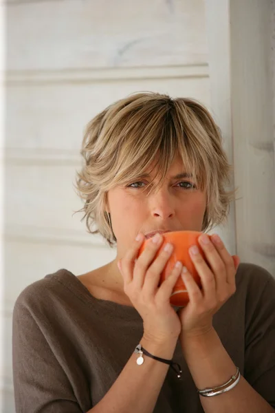 Woman drinking from a bowl — Stock Photo, Image
