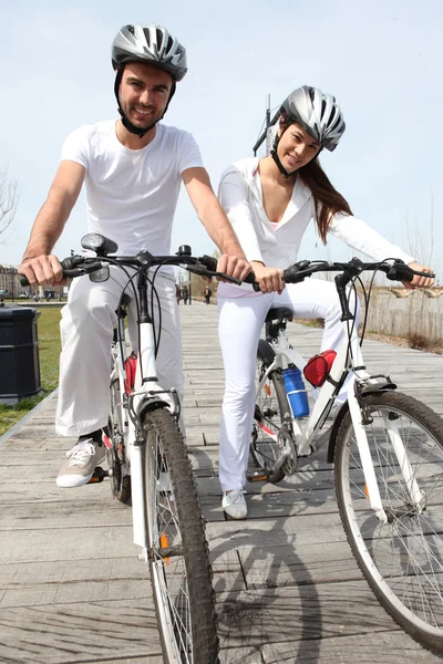Молодая пара, катающаяся на велосипеде — стоковое фото