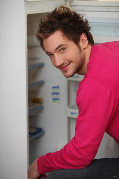Young man looking in the fridge Stock Photo