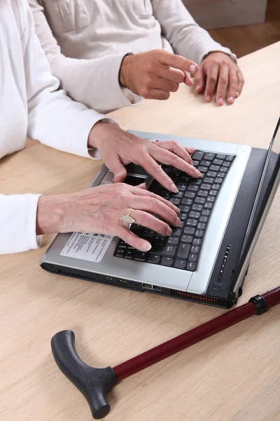 Senior mulher tocando um teclado de computador — Fotografia de Stock