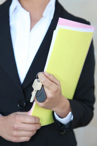 Businesswoman with files and keys — Stock Photo, Image