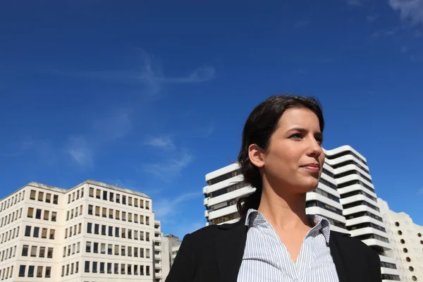 Uma mulher de negócios andando perto de edifícios — Fotografia de Stock