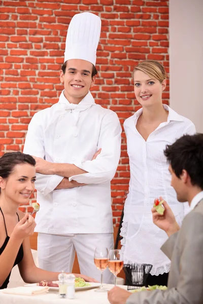 A chef and a waitress working in a restaurant Royalty Free Stock Photos